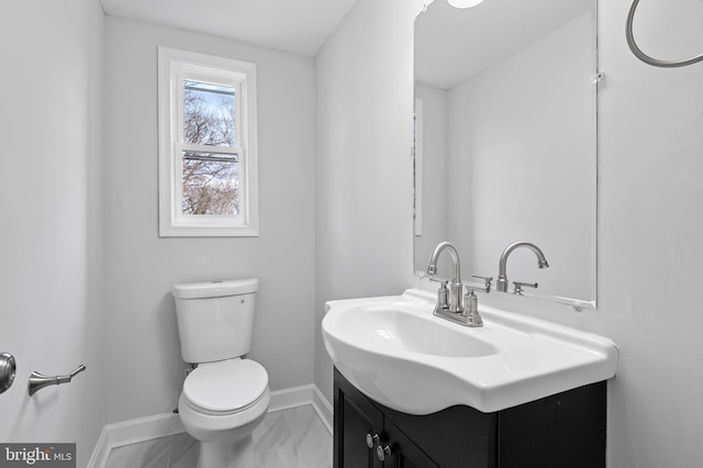 bathroom with marble finish floor, baseboards, vanity, and toilet