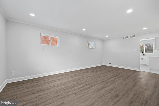 unfurnished room with baseboards, wood finished floors, and crown molding