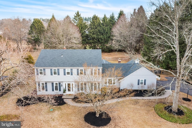 view of front of property with roof with shingles and a chimney