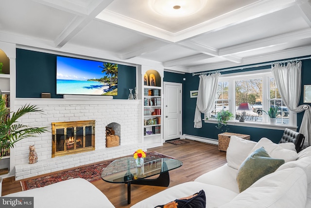 living area with coffered ceiling, a baseboard radiator, wood finished floors, a fireplace, and beam ceiling