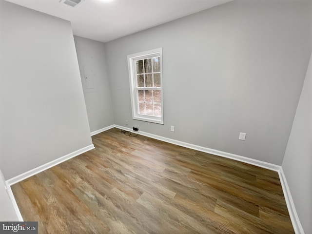 spare room featuring visible vents, baseboards, and wood finished floors