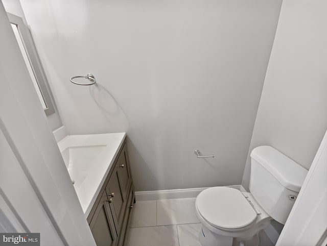 half bath featuring toilet, marble finish floor, vanity, and baseboards