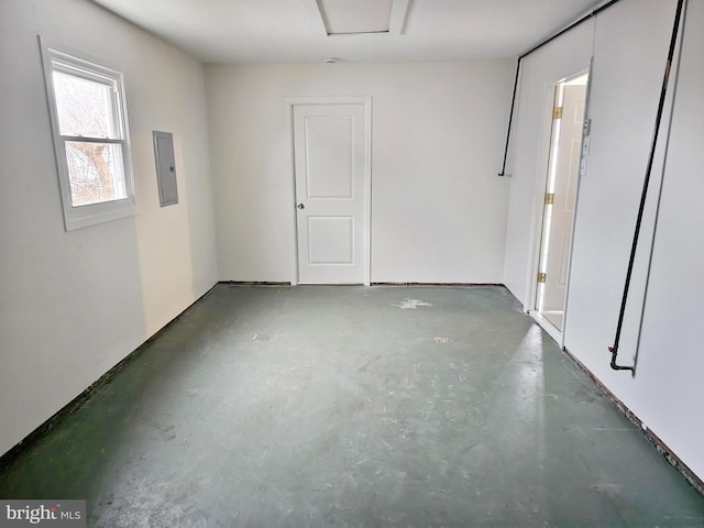 spare room with concrete flooring and electric panel