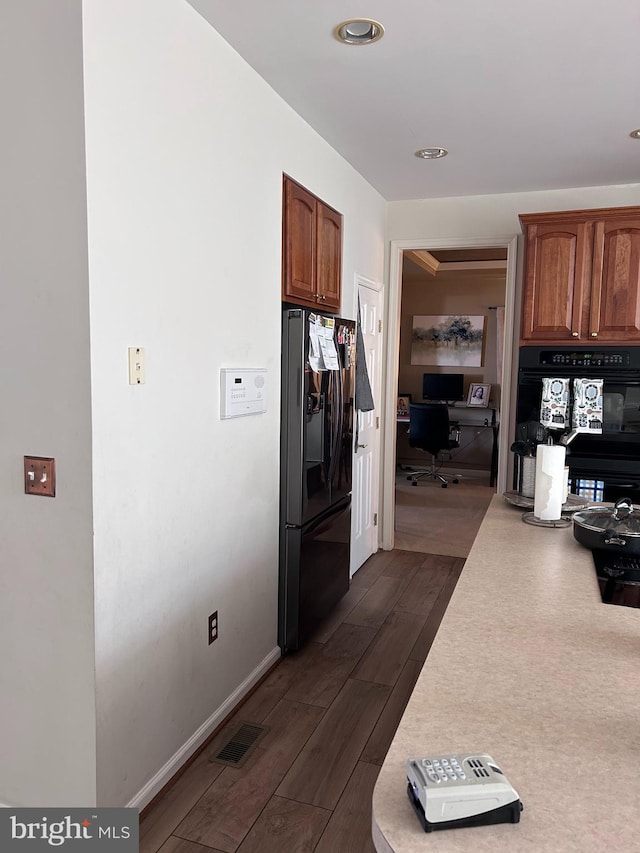 corridor with visible vents, dark wood-style flooring, and baseboards