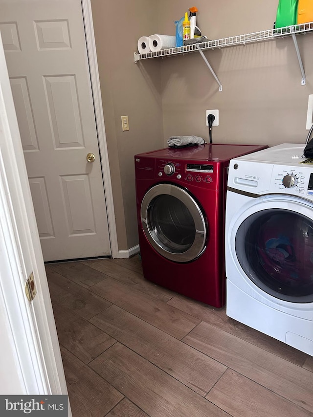 laundry room with washer and clothes dryer, laundry area, and wood finished floors