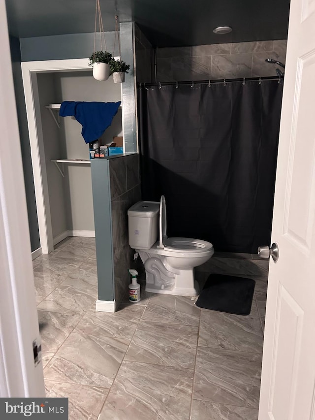 full bath featuring marble finish floor, toilet, and a shower with shower curtain