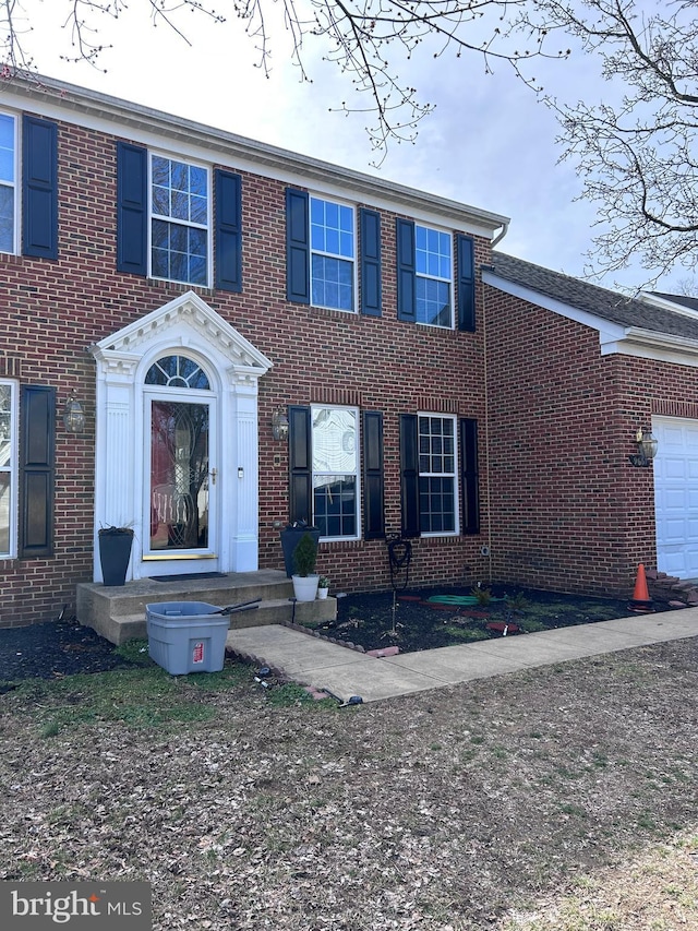 view of front of property with a garage and brick siding