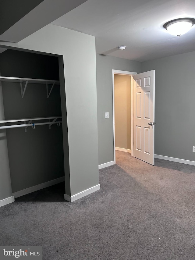 unfurnished bedroom with a closet, baseboards, and carpet floors