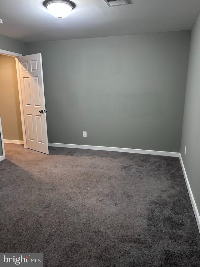 unfurnished room with baseboards and carpet floors