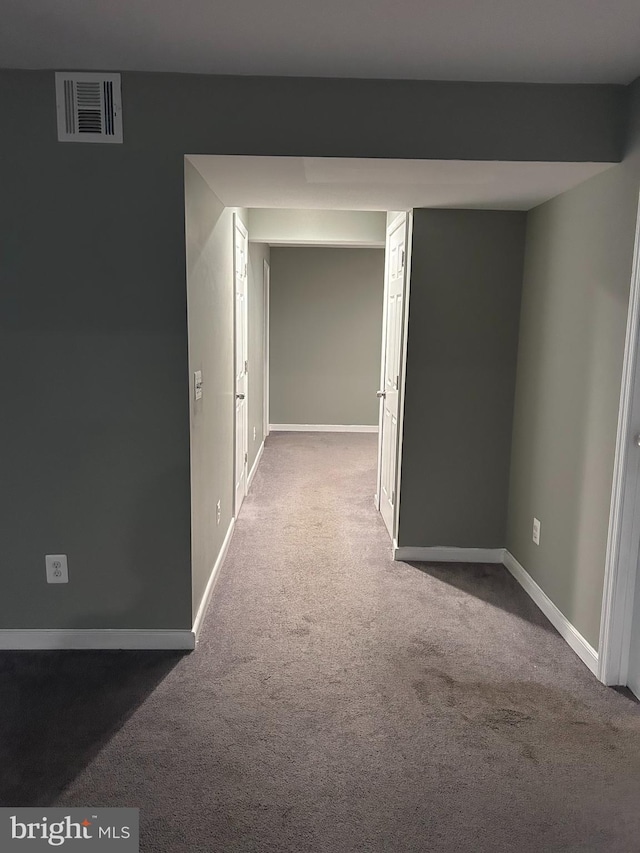 corridor with visible vents, baseboards, and carpet floors