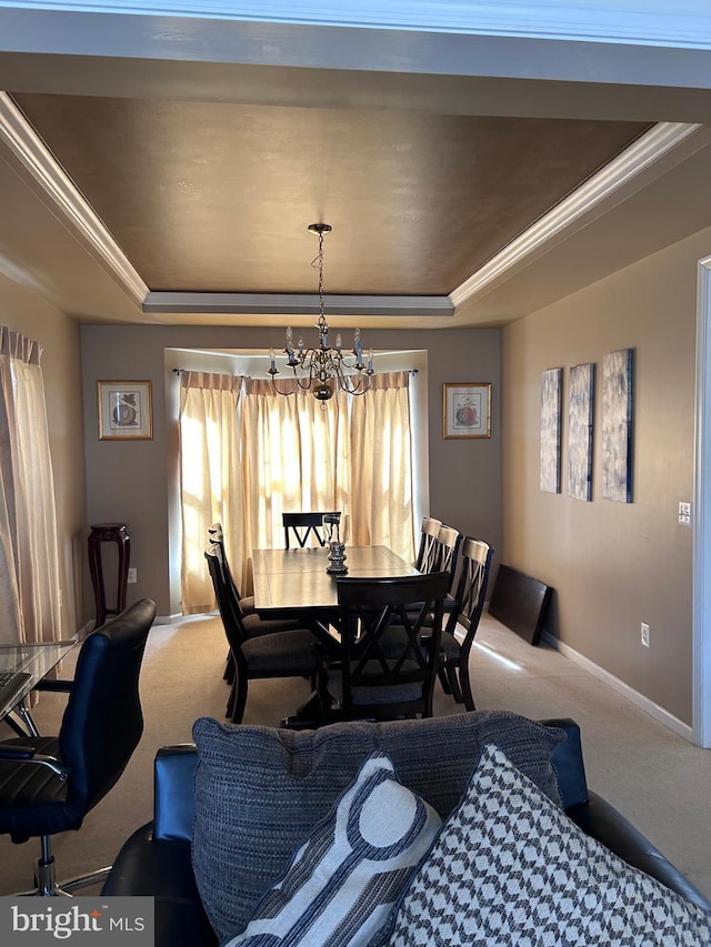 dining space with a chandelier, carpet flooring, a raised ceiling, and baseboards