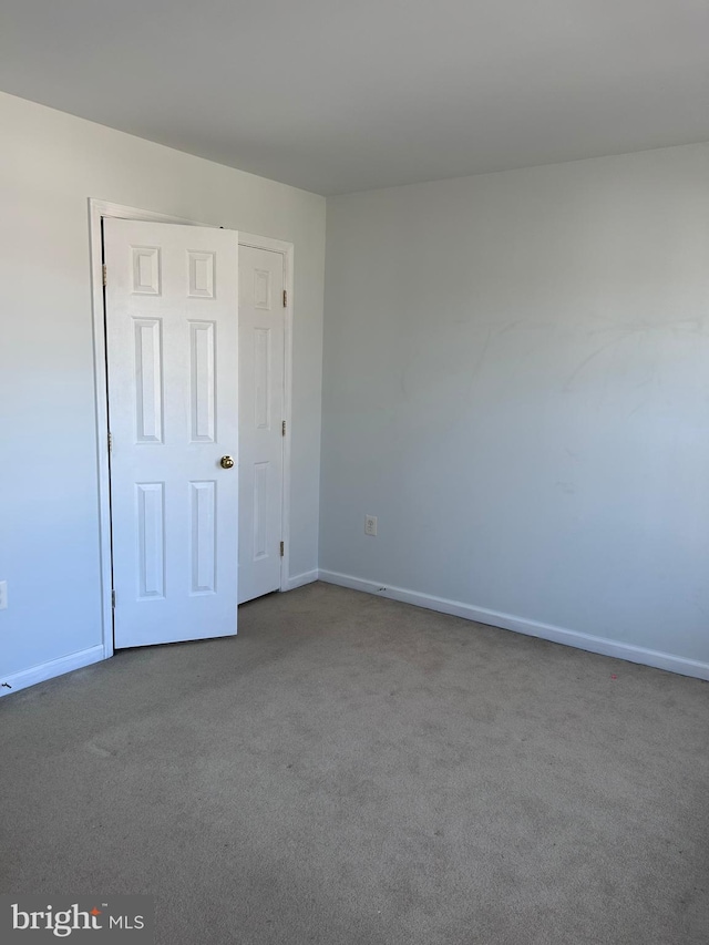 spare room featuring baseboards and carpet floors