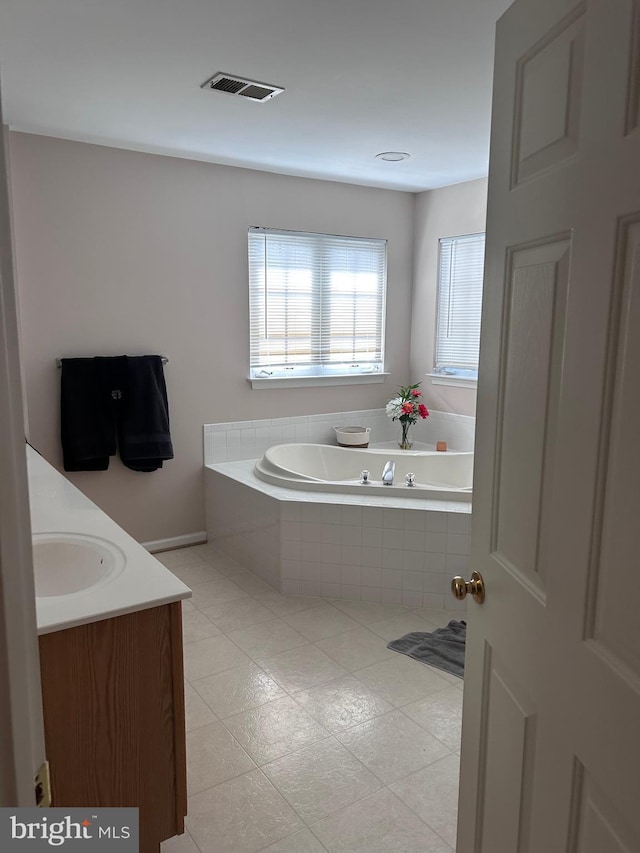 bathroom featuring a bath, visible vents, and vanity