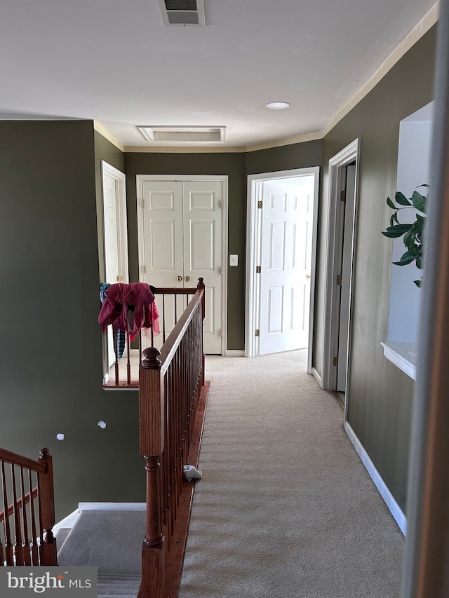 corridor featuring visible vents, an upstairs landing, baseboards, and carpet floors