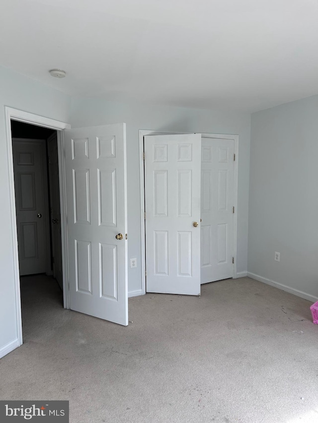 unfurnished bedroom featuring baseboards and carpet flooring