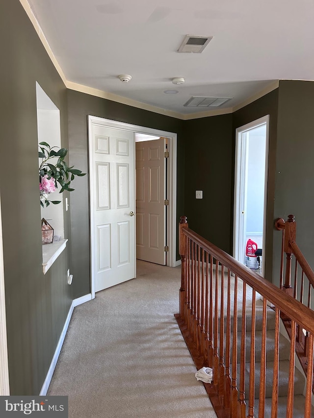 corridor with visible vents, an upstairs landing, light colored carpet, and baseboards