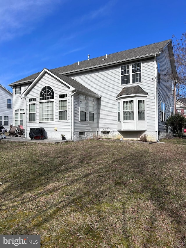 rear view of property featuring a lawn