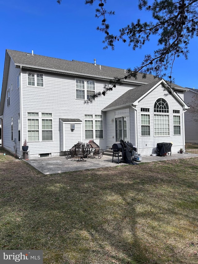 rear view of house with a lawn, roof with shingles, and a patio area