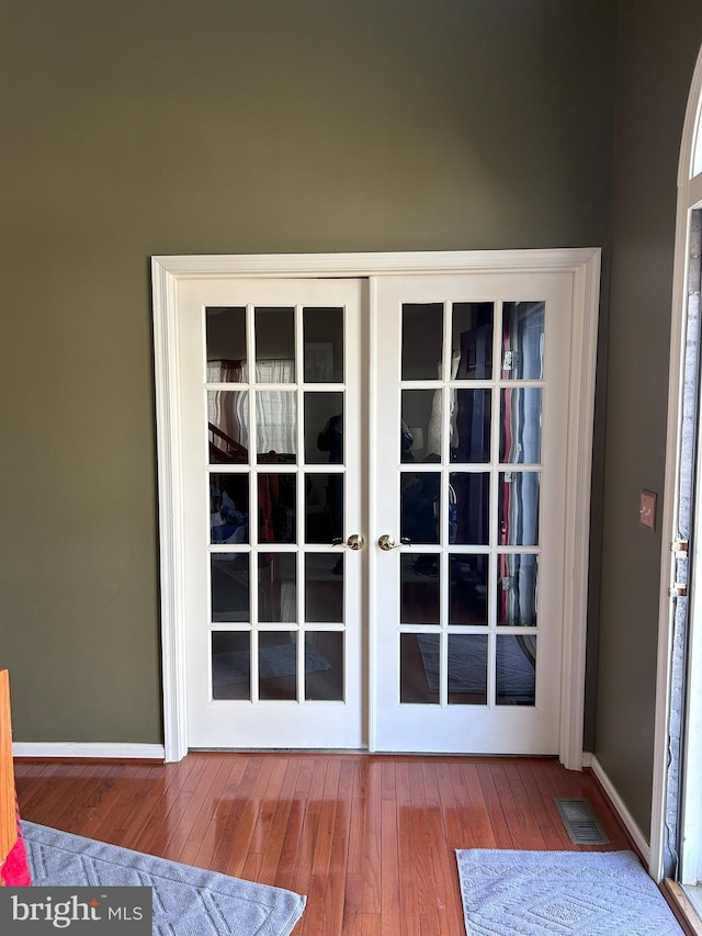 entryway with visible vents, french doors, baseboards, and wood-type flooring