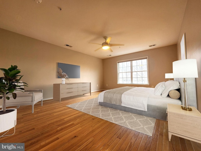 bedroom featuring hardwood / wood-style flooring, visible vents, and baseboards