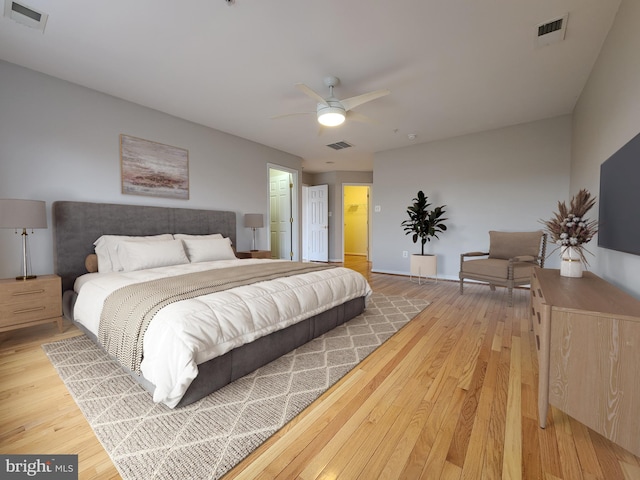 bedroom with light wood-style floors, visible vents, and a ceiling fan