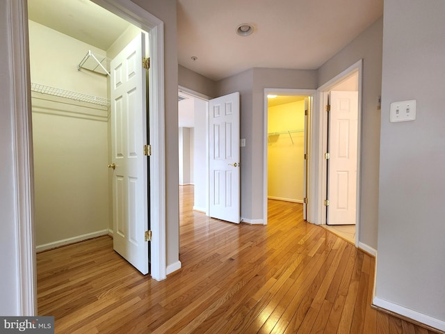 hall with light wood finished floors and baseboards