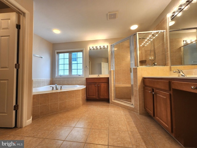 bathroom featuring two vanities, visible vents, a stall shower, tile patterned flooring, and a bath