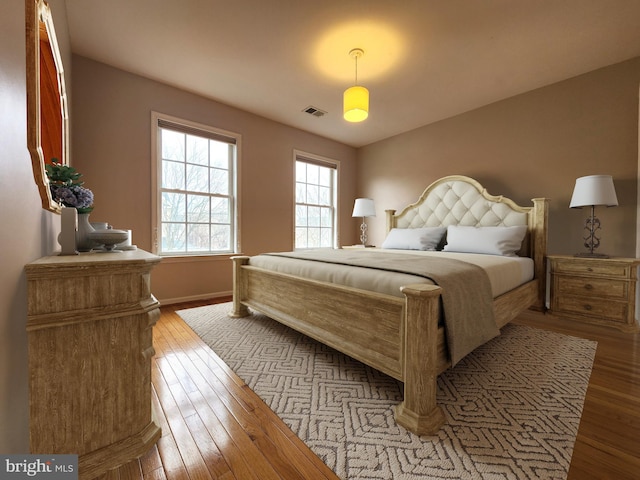 bedroom with visible vents, baseboards, and hardwood / wood-style flooring