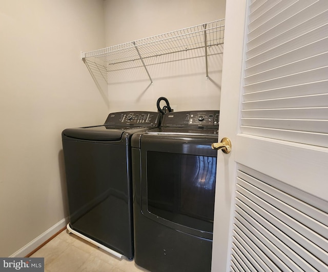 laundry area with laundry area, baseboards, and separate washer and dryer