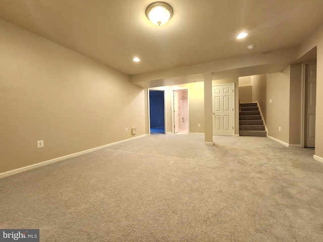 finished below grade area featuring stairs, recessed lighting, light carpet, and baseboards