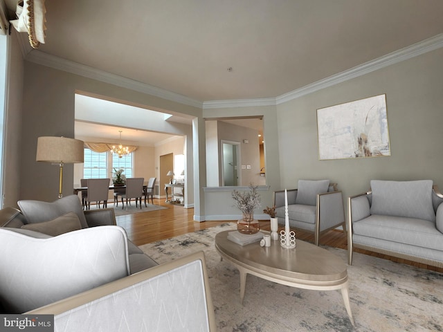 living area with a chandelier, crown molding, baseboards, and wood finished floors