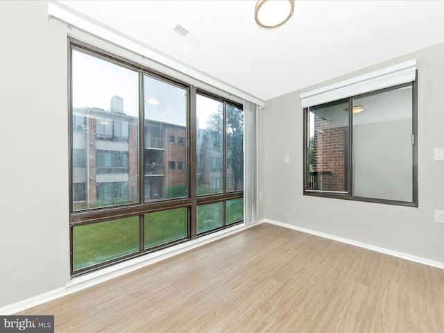 empty room with baseboards and wood finished floors