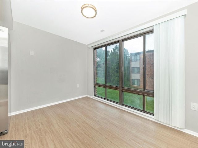 unfurnished room featuring baseboards and wood finished floors