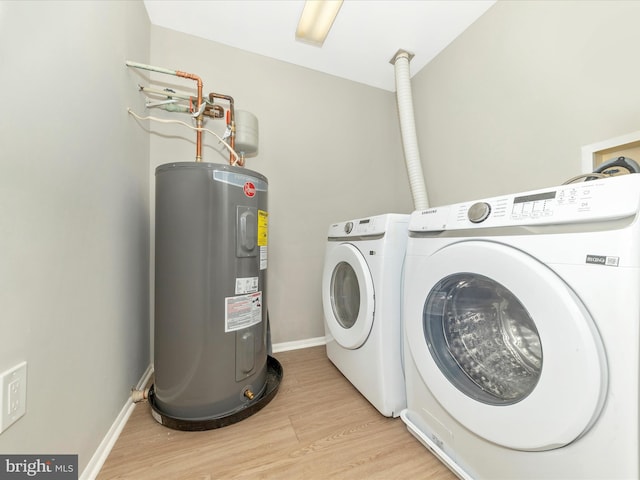 clothes washing area with laundry area, baseboards, light wood-type flooring, washing machine and dryer, and water heater