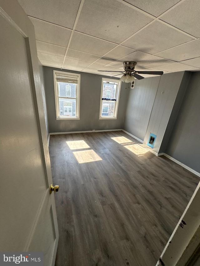 unfurnished room featuring a paneled ceiling, a ceiling fan, baseboards, and wood finished floors