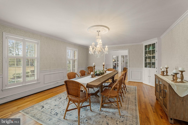 dining area featuring a wainscoted wall, a wealth of natural light, and crown molding