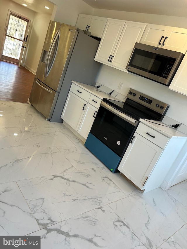 kitchen featuring stainless steel appliances, light countertops, marble finish floor, and white cabinets