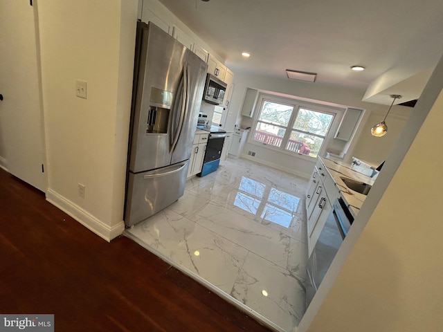 kitchen with marble finish floor, white cabinetry, appliances with stainless steel finishes, and baseboards