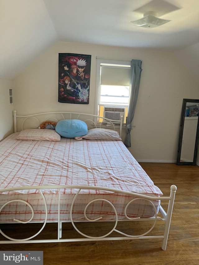 bedroom with vaulted ceiling, cooling unit, wood finished floors, and visible vents