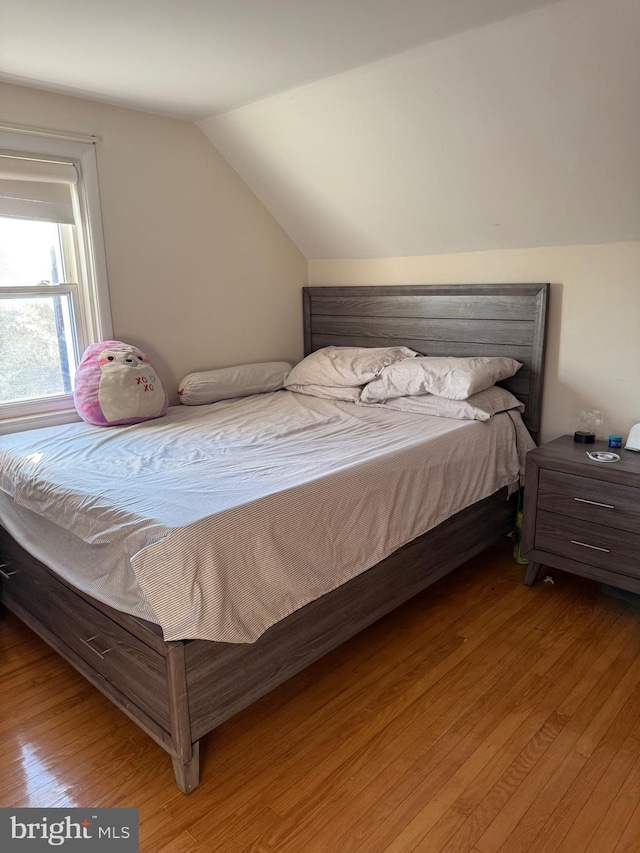 bedroom featuring light wood-style floors and vaulted ceiling