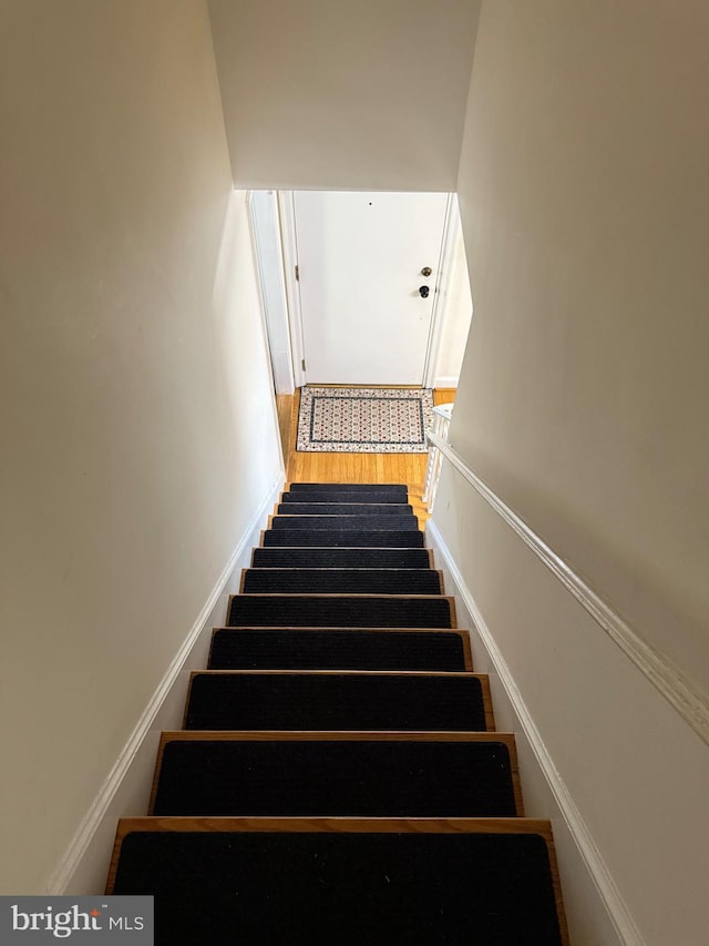 stairway featuring wood finished floors and baseboards