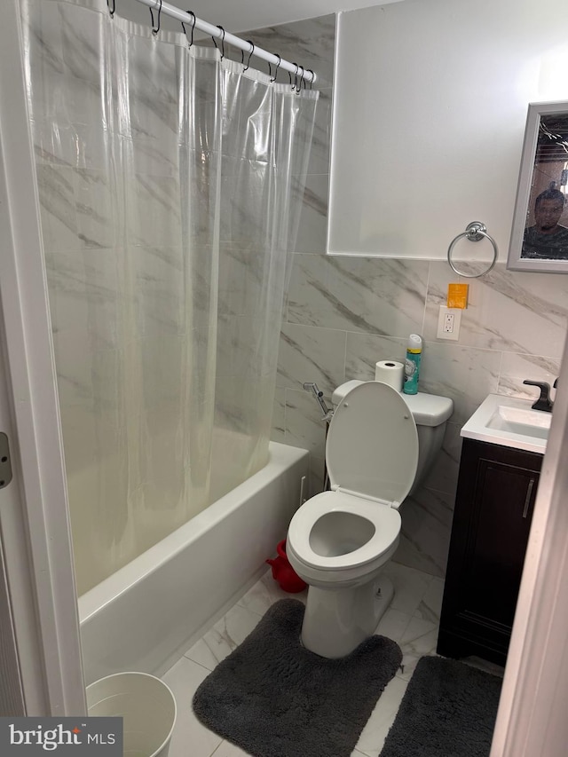 bathroom with marble finish floor, vanity, toilet, and shower / bath combo with shower curtain