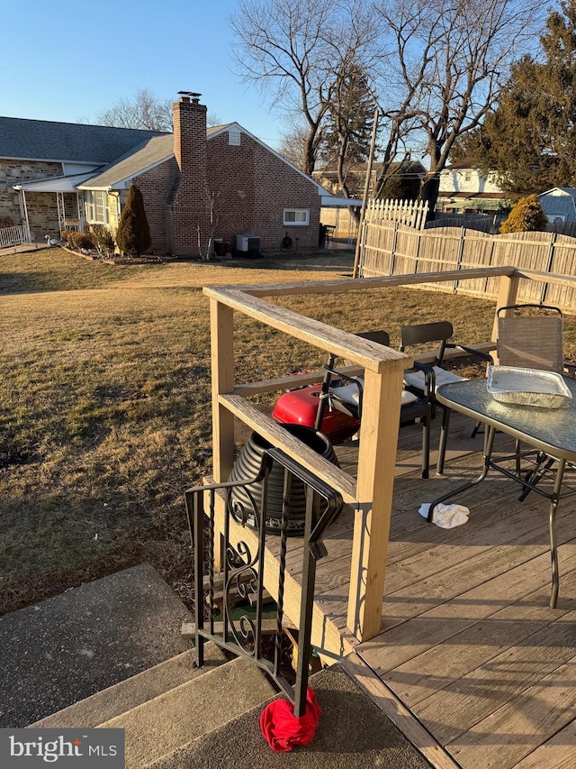 wooden deck featuring a lawn and fence