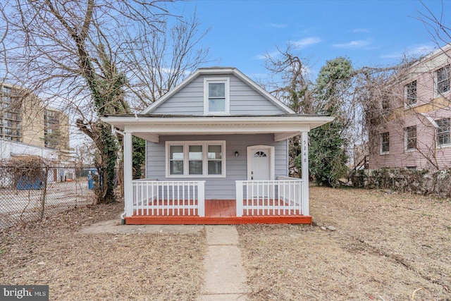 bungalow-style home with a porch and fence