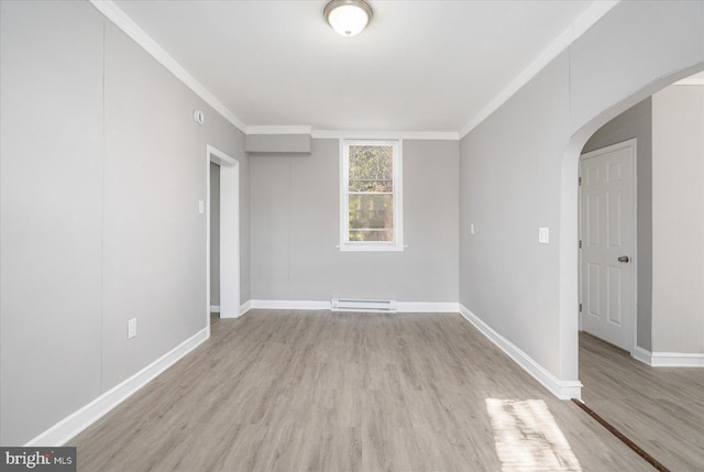 empty room featuring a baseboard heating unit, arched walkways, light wood-style floors, and ornamental molding