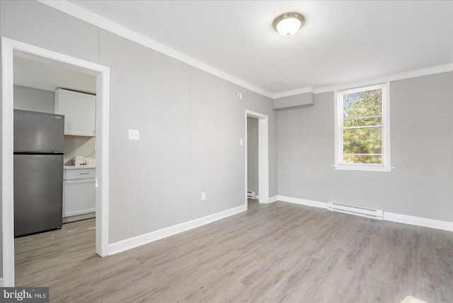 empty room featuring a baseboard heating unit, light wood-style floors, and ornamental molding