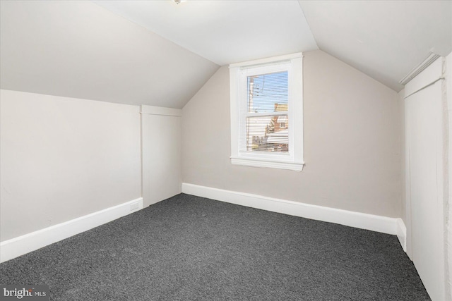 bonus room featuring lofted ceiling, baseboards, and dark colored carpet