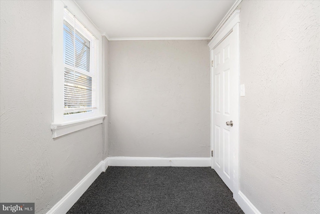 empty room with baseboards, a textured wall, carpet, and crown molding