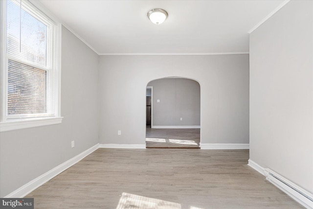 empty room with arched walkways, a baseboard heating unit, ornamental molding, wood finished floors, and baseboards