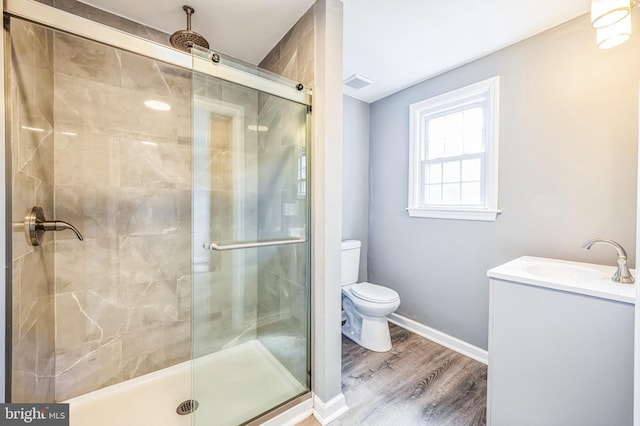 full bath featuring a stall shower, baseboards, visible vents, toilet, and wood finished floors